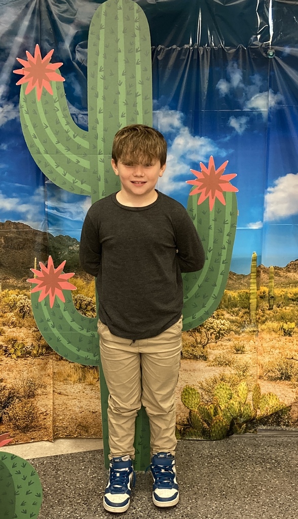 Student standing in front of cactus.